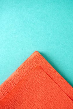 kartondan yapılmış mavi arka planda kırmızı kağıt peçete parçası, kopya alanı, dikey üst görünüm
