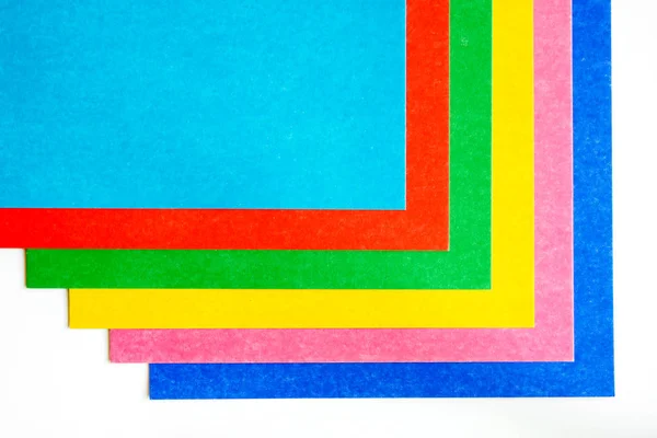 Patrón gráfico de hojas de cartón de colores sobre un fondo blanco. Copiar espacio, vista superior —  Fotos de Stock