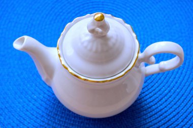 mavi hasır paspas, yumuşak seçici odak bir arka plan üzerinde beyaz çaydanlık