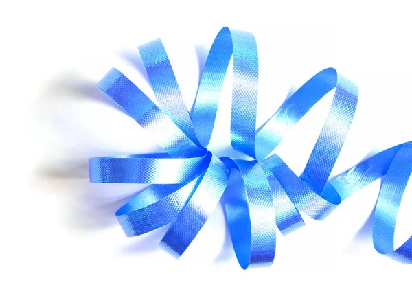 Close-up of blue curling ribbon for gift wrapping art and crafts on white background, top view