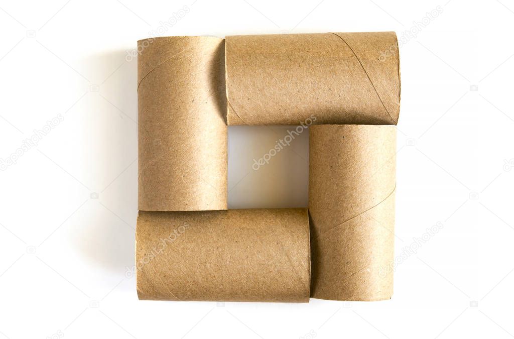 Square formed from of four cardboard paper tubes on white background. Close-up of empty toilet rolls, top view