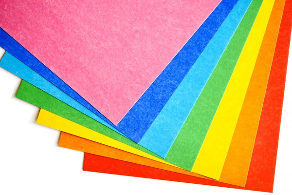 Montón de varias hojas de cartón de colores sobre un fondo blanco, vista superior —  Fotos de Stock