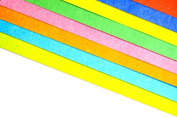Multicolored stripes at an angle from paperboard on white background, top view — Stock Photo, Image