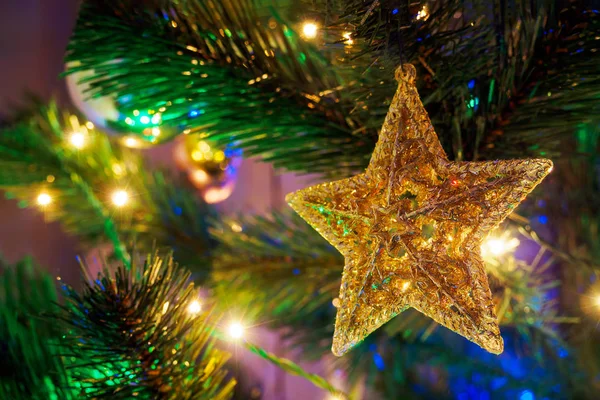 花輪と緑の背景にぶら下がる星の形でクリスマスのおもちゃ。コピースペース、選択的フォーカス — ストック写真