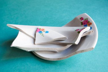 Kırık beyaz tabak yığını mavi arka planda. Parçalanmış aile ya da akrabalık kavramı