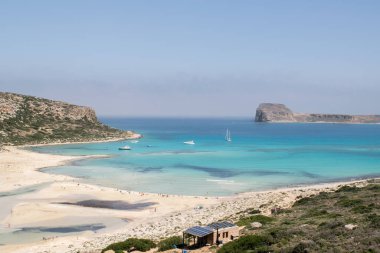 Güneşin ve denizin tadını çıkarıyor.