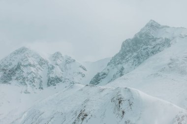 Metinler için kış dağları, kayaların ve dağların karlı tepelerinde buzlu mavi gökyüzü vahşi hayvanlar için kuru otlar, kayak ve snowboard için bir yer, peynirli kekler için olduğu kadar temiz hava için de