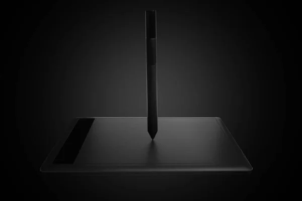 Top view of a modern graphics tablet isolated on a black background, pen for working with graphics on special equipment to help with computer work, innovation 2020