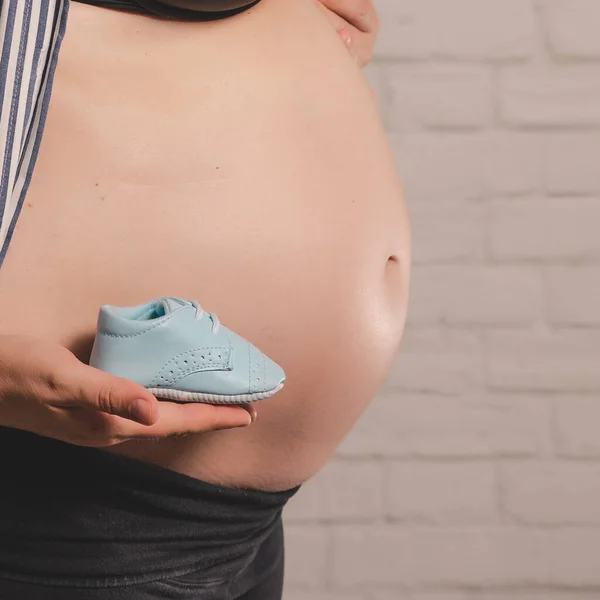 Pregnant happy Woman touching her belly. Full length Pregnant beauty young mother outdoor portrait, caressing her belly and smiling. Healthy Pregnancy concept, brunette expectant female in summer park