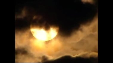 night.the moon sets behind a cloud. it's getting dark.there will probably be a lot of clouds, thunderstorms and rain.