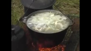 Izgarada bir ateş yanıyor. Bir kazan, içinde yemek hazırlanıyor..