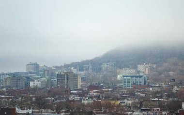 Down Town 'a daha yakın olan Royal Dağı' nın 10. kattaki plato bölgesinden uzun bir objektifle çekilmiş görüntüsü. Dağ sisle kaplı.