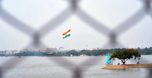 Indian flag waving in a air on independence day of india. view of flag through wire Fench