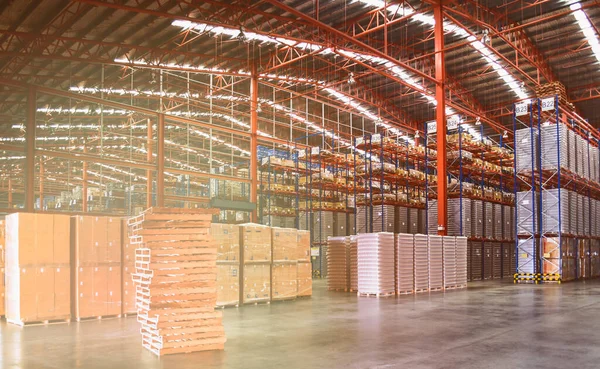 Ahşap paletler ve kargo paletleri büyük bir depoda. Depo lojistik operasyonları. Depo işçisi ve forklift sürücüsü.