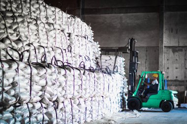 Forklift şeker torbasını deponun içine istiflemek, şeker deposu operasyonu. İthalat ve ihracat için tarım ürünü depolama ve lojistik.