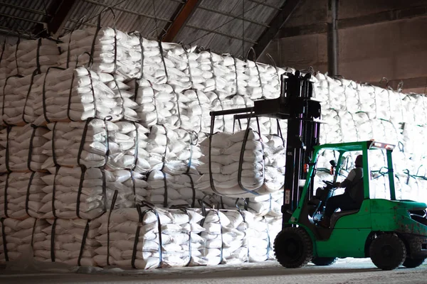 Forklift şeker torbasını deponun içine istiflemek, şeker deposu operasyonu. İthalat ve ihracat için tarım ürünü depolama ve lojistik.