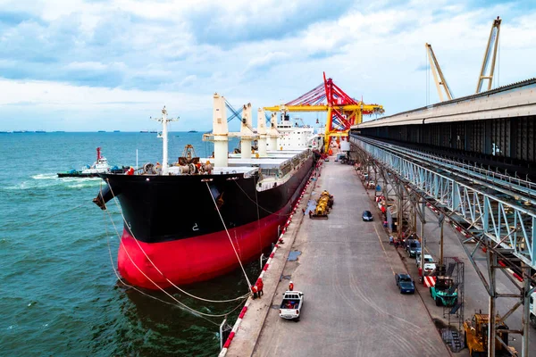 Large bulk cargo vessel berthing at port discharging cargo.