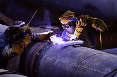 Koruyucu maskeli işçiler inşaat alanında metal kaplama taşıyordu.