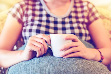 Kahve dükkanında ellerini yastığa koyup dinlenen bir kadın.