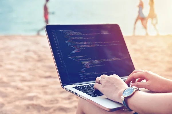 Plajda rahat bir çalışma ortamında kaynak kodlar yazan bir programcı. Öğrenim, Çalışma, Teknoloji, Serbest Çalışma Konsepti.