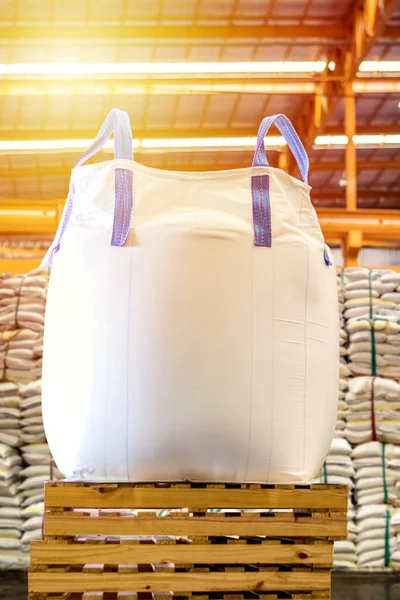 Tahta paletin üzerine kocaman şeker torbalarının arka planına sahip bir jumbo poşeti kapat..
