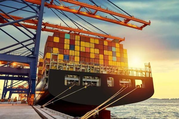 İş ve lojistik ihracat ve ithalat yapan konteyner gemisi. Liman terminalinde büyük bir Panamax konteynır yükü boşaltılıp yükleniyor. Rıhtım vinci kamyondan gemiye konteynır alıyor..