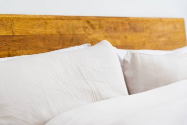 Yatağın üzerindeki beyaz, rahat yastığı kapattım. Minimalist yatak ve yaşam alanı.