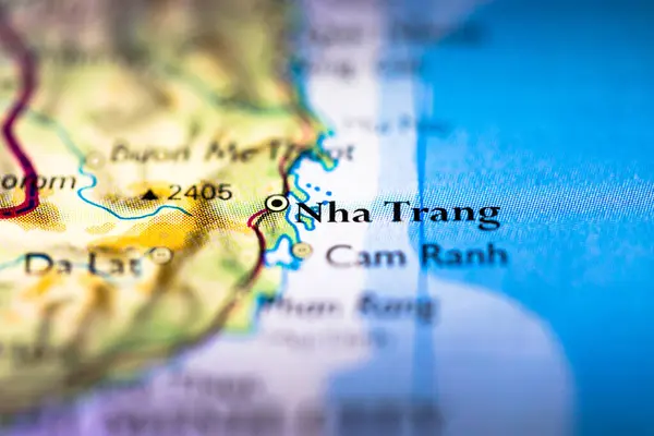 Shallow depth of field focus on geographical map location of Na Trang city in Vietnam Indochina Asia continent on atlas