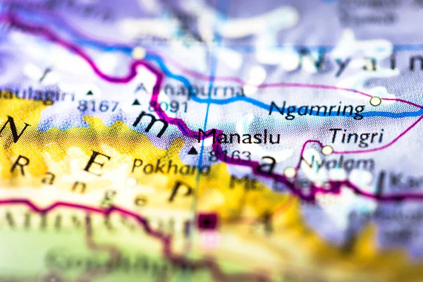 Shallow depth of field focus on geographical map location of Mount Manaslu in Nepal in Asia continent on atlas