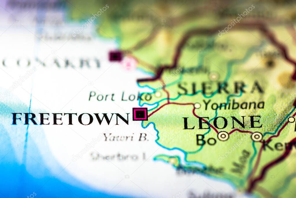 Shallow depth of field focus on geographical map location of Freetown city in Sierra Leone Africa continent on atlas