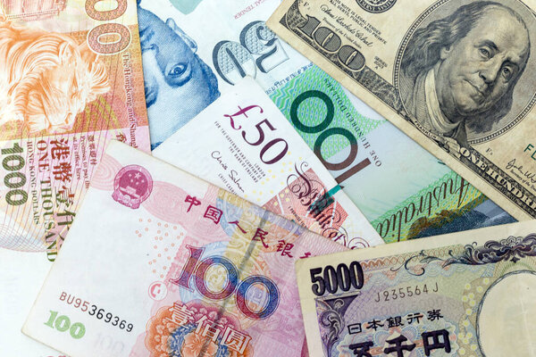 Currency banknotes spread across frame including world major currencies