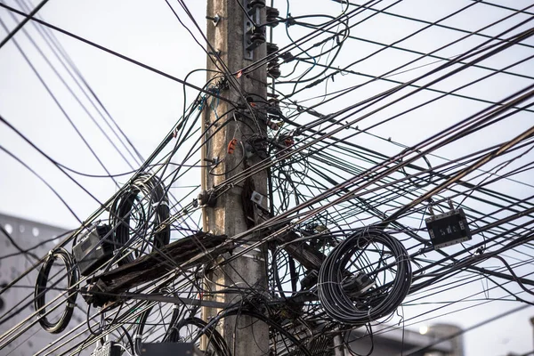 Chaotic Intertwining mess of electricity power lines on pole