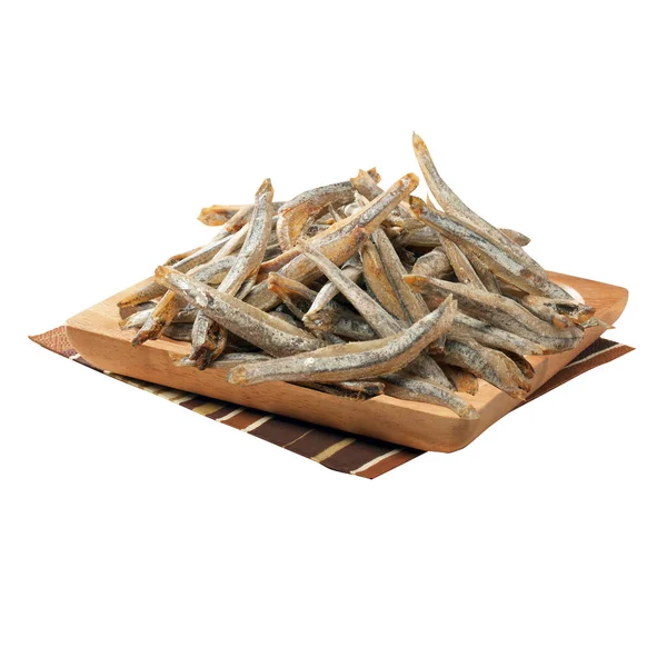 Kare bir tabakta küçük kurutulmuş balık ve çizgili bir peçete.