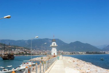 Denizde beyaz deniz feneri. Şehir ve körfez.