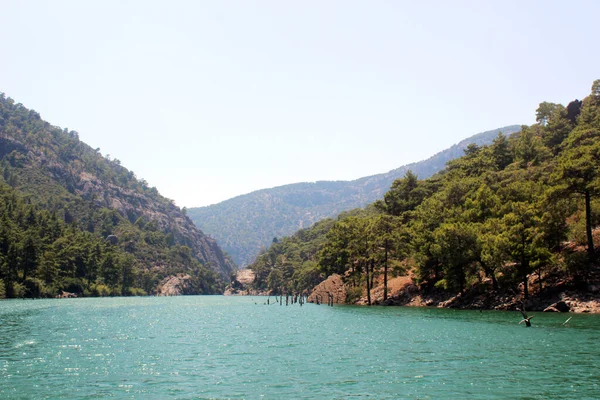 Turkuaz göl, yeşil dağların ve kayaların ortasında. Peyzaj.