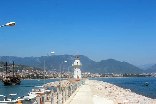 Denizde beyaz deniz feneri. Şehir ve körfez.