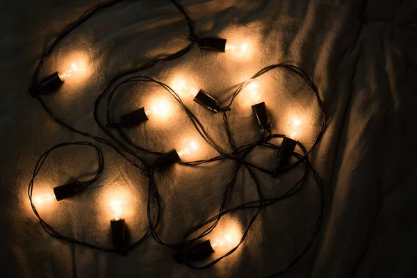 Parlak ampuller yerde yatıyor. Ampul çelengi.