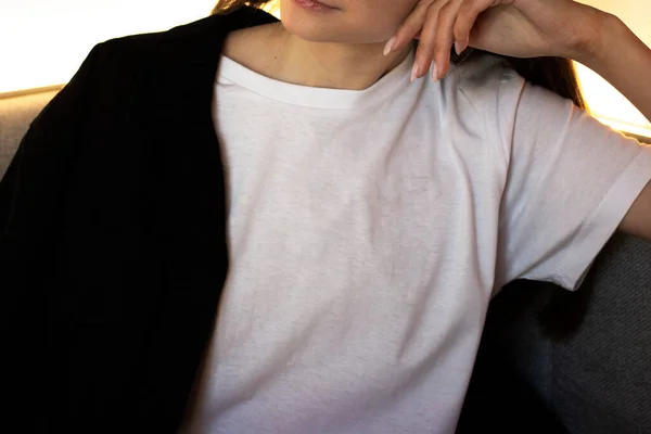 Beyaz tişörtlü genç bir kadın. Bir giyim markası için. Model.