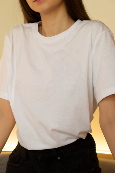 Beyaz tişörtlü genç bir kadın. Bir giyim markası için. Model.
