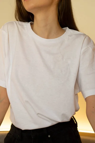 Beyaz tişörtlü genç bir kadın. Bir giyim markası için. Model.