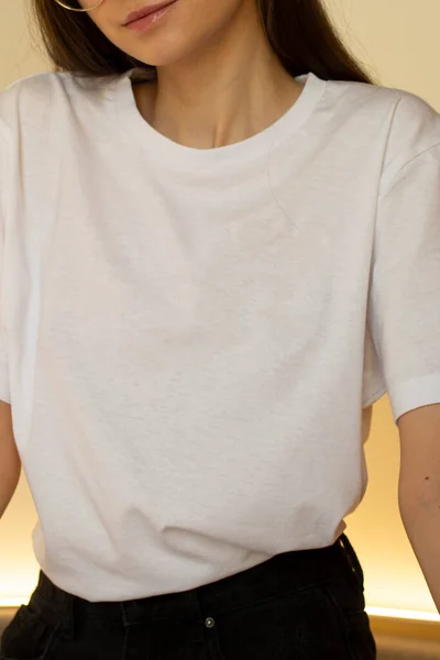 Beyaz tişörtlü genç bir kadın. Bir giyim markası için. Model.
