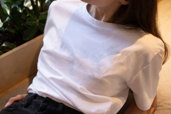 Beyaz tişörtlü genç bir kadın. Bir giyim markası için. Model.