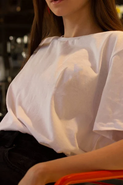 Beyaz tişörtlü genç bir kadın. Bir giyim markası için. Model.