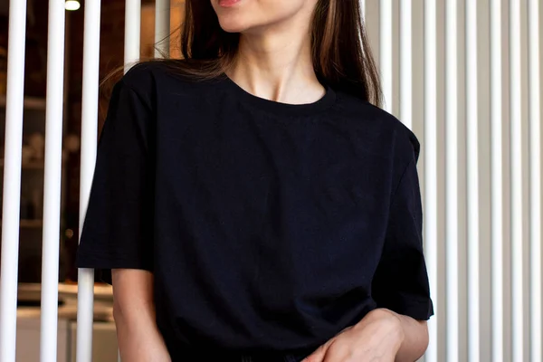 Siyah tişörtlü ve siyah etekli genç bir kadın. Bir giyim markası için. Model.