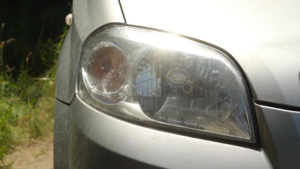 汽车的前灯在右边闪烁着 森林路上一辆灰色汽车的前右前灯闪烁着黄色的光芒 — 图库视频影像