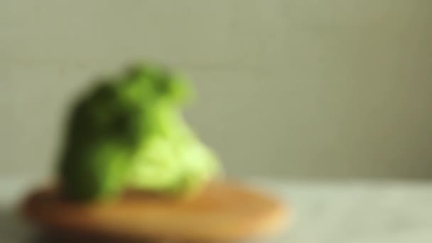 重点转移到花椰菜上 从注意力不集中到把新鲜的绿花椰菜集中在木制厨房板上的缓慢注意力 — 图库视频影像