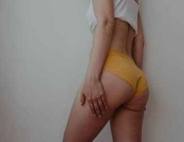 Sarı iç çamaşırlı kadın kalçaları