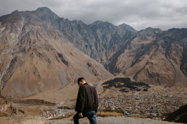 Kazbegi dağlarında yürüyen adam.