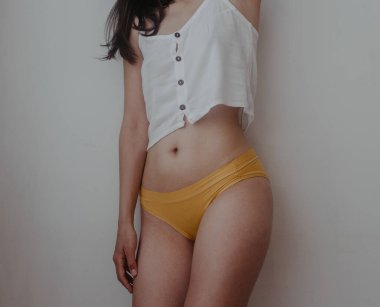 Sarı iç çamaşırlı kadın kalçaları ve midesi.