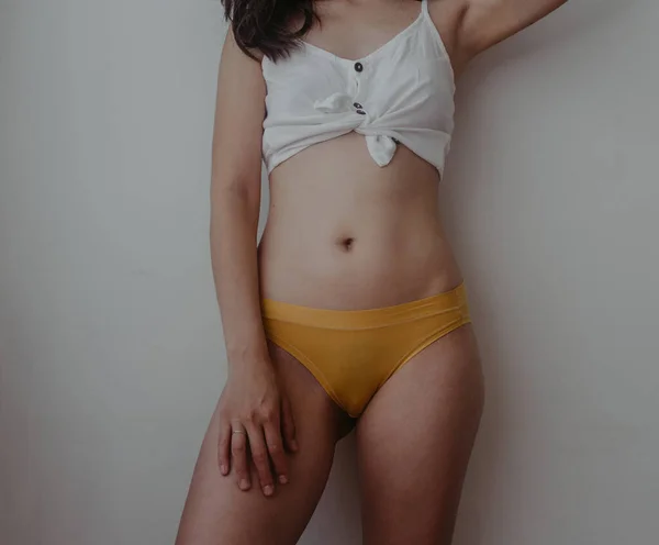 黄色いランジェリーに身を包んだ女の腰と胃 — ストック写真